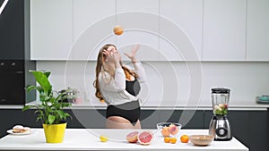 Dancing happy bbw or fatty with grapefruit in hand dressed in black leotard. Dancing in the kitchen curvy body girl