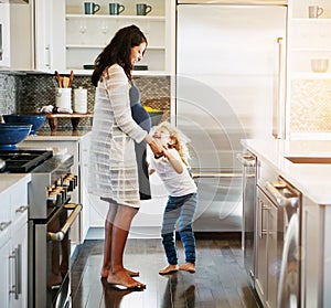 Dancing, happy and pregnant mother with child in kitchen listening to music, radio or playlist. Smile, love and mom