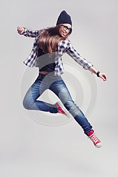 Dancing hipster girl in glasses and black beanie