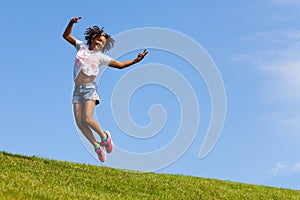 Dancing and jumping cute girl on the lawn in park