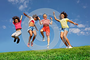 Dancing and jumping group of diverse kids on lawn
