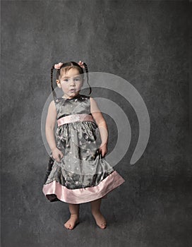 Dancing little girl in gray and pink dress