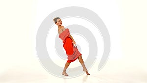Dancing and moving, young woman in red long dress