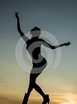 Dancing silhouette of woman ballet dancer in twilight silhouetted on evening sky, ballet