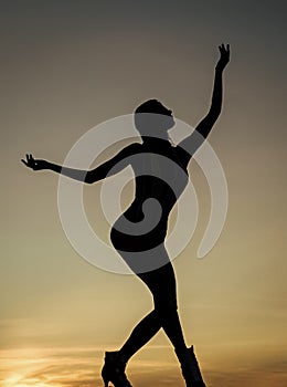 Dancing silhouette of woman ballet dancer in twilight silhouetted on evening sky, ballet