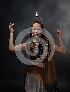 Dancing woman with a candlestick in the national Indian sari