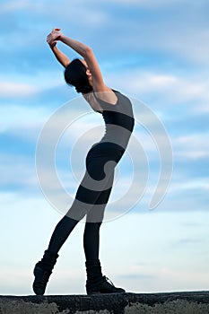 Dancing woman over blue sky. Yoga