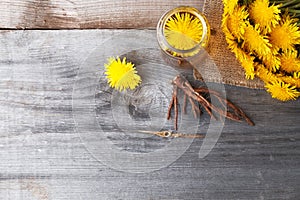 Dandelion broth in a glass jar on  vintage wooden background with copy space, medicinal herbs, herbal medicine, traditional