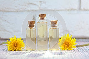 Dandelion essential oil in  beautiful bottle on White background