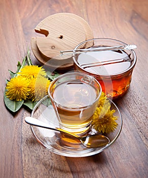 Dandelion herbal tea and honey with yellow blossom on wooden table