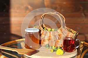 Dandelion jam and tea mug on the countryside