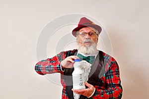 A dandy of a man olding a bottle of bleach.