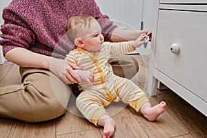Danger for the baby to pinch the hand of the cabinet door or chest of drawers. Protect children from home furniture, kids safety