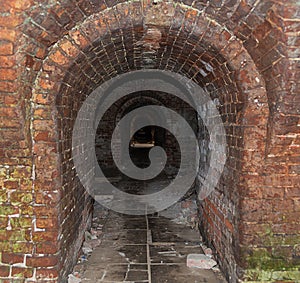 Danger Dark brick tunnel of the catacomb with arched entrance view to the darkness