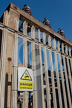 Danger of death keep out warning sign on a palisade fence