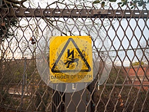 danger of death yellow rusty dirty unclean sign on metal fence l
