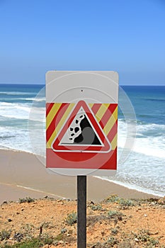 Danger falling rocks sign near a beach