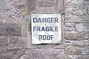 Danger fragile roof sign on wall at farm house