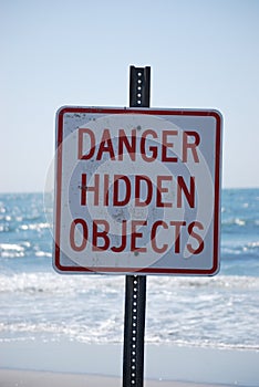 Danger Hidden Objects Sign on the beach photo