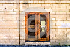 Danger high voltage sign on wooden door on stone brick wall in england uk