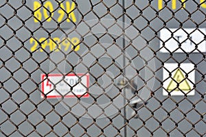 The danger of high voltage. steel mesh fence high-voltage transformer substation outside. Soft focus. Abstract background for