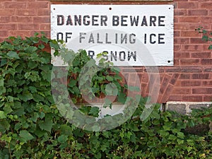 Danger Ice Falling Sign Posted on Brick Wall