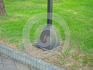 Danger icon on the base of a street lamp. Electrical safety concept. Danger icon in the form of a lightning bolt. Under tension