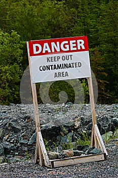 A danger keep out of contaminated area sign on rocky ground