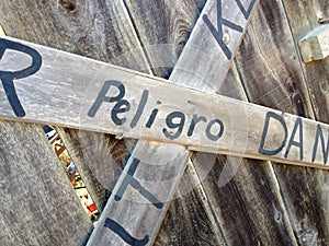 Danger keep out peligro sign painted on wood fence photo