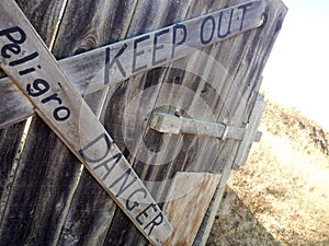 Danger keep out peligro sign painted on wood fence photo