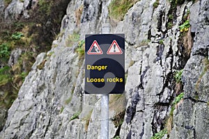 Danger loose rocks steep cliff boulders caution sign for climbing