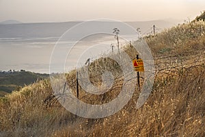 Danger mines - yellow warning sign next to a mine field, close to the border with Syria, in the Golan Heights, Israel