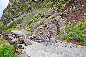 Danger mountain landslide stone slope threaten to block road for driver and resident of the city.