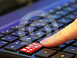 Danger online internet dark web hate crime user finger pressing pushing red button computer