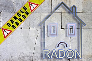 The danger of radon gas in our homes - concept with an outline of a small house with radon text against a cracked stone wall