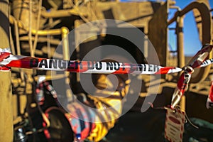 Danger red and white tape barricade exclusion area at confined space entry door authorised personnel only