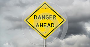 Danger road sign with storm clouds