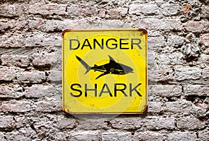 Danger Shark yellow warning sign on a wall