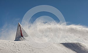 Danger sign, covered with snow, on the Sunny day, on top of Rose Peak mountain