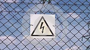 Danger sign of high voltage damage. Electricity of the net. Substation behind the fence. Warning sign of danger. high