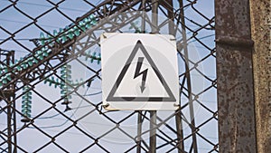 The danger sign of high voltage on the fence of the power plant. Risk of electric shock. Power generators, electricity