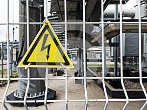 Danger Sign High voltage in a yellow triangle on a metal grid