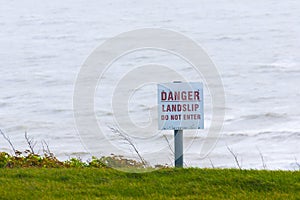 Danger sign for public information sign next to sea cliff