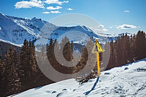 Danger sign on side of the mountain ski track in mountains