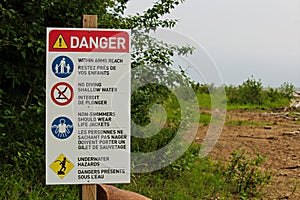 A danger sign with various beach rules on it