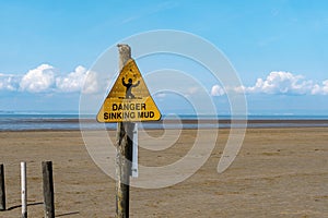 Danger Sinking Mud on a yellow beach sign