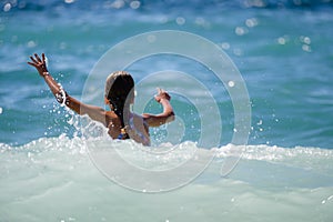 Danger storm weather with little girl swimming in high waves in sea during summer vacation with copy space