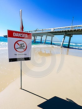 Danger swimming sign beach, red flag