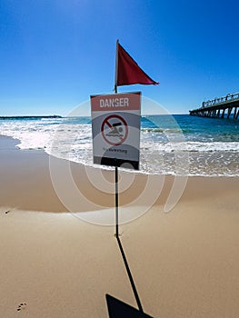 Danger swimming sign beach, red flag