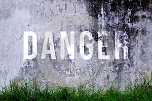 Danger text written with broken cement wall, Danger word on street